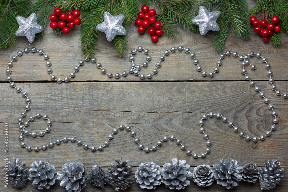 Christmas card concept with fir tree branches, rowan berries, silver cones, bead chain and silver glitter stars on wooden background - text space Christmas card concept with fir tree branches, rowan berries, silver cones, bead chain and silver glitter stars on wooden background - text space