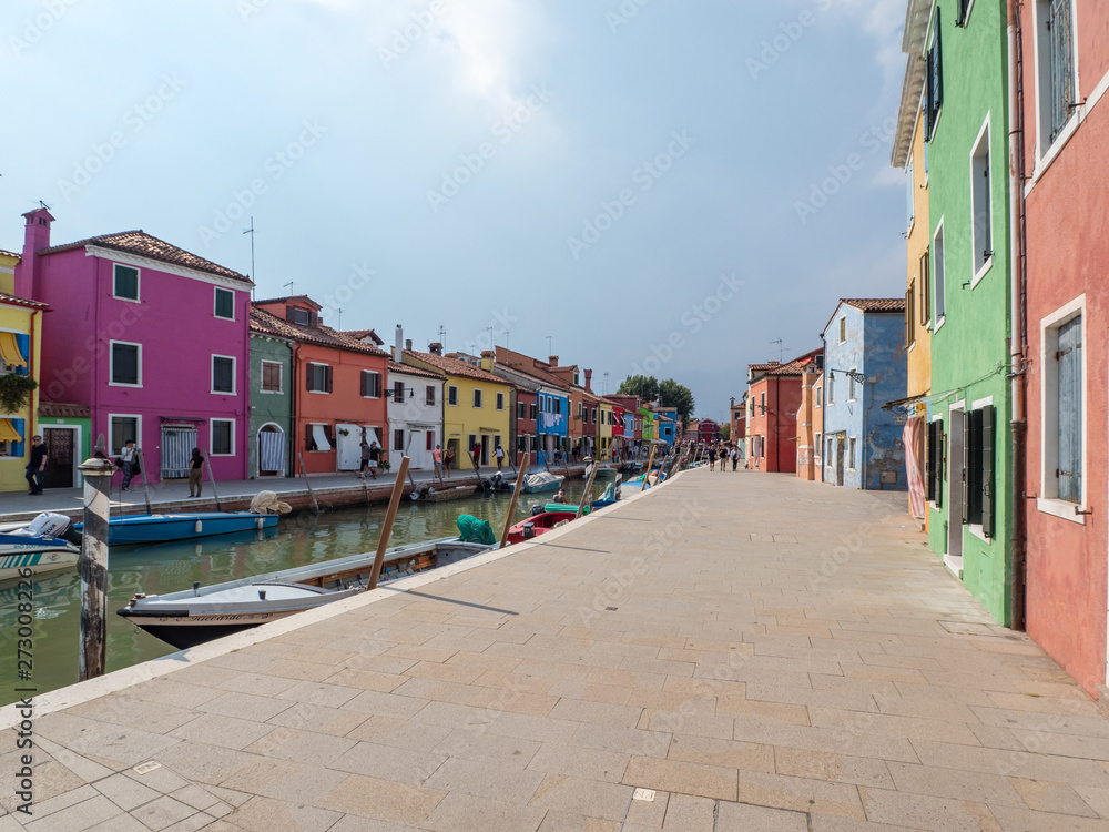Colorful houses at sunny day in Burano, Venice Italy. Facades on island in the morning, august 2018