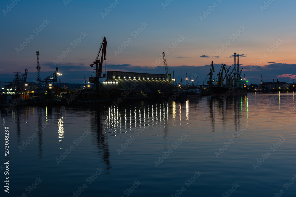 Burrgas Sea Port at night. Silhouettes of cranes and reflections in the water