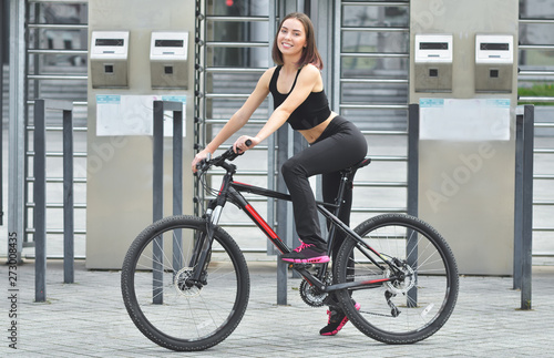 Young beautiful girl standing with her bicycle
