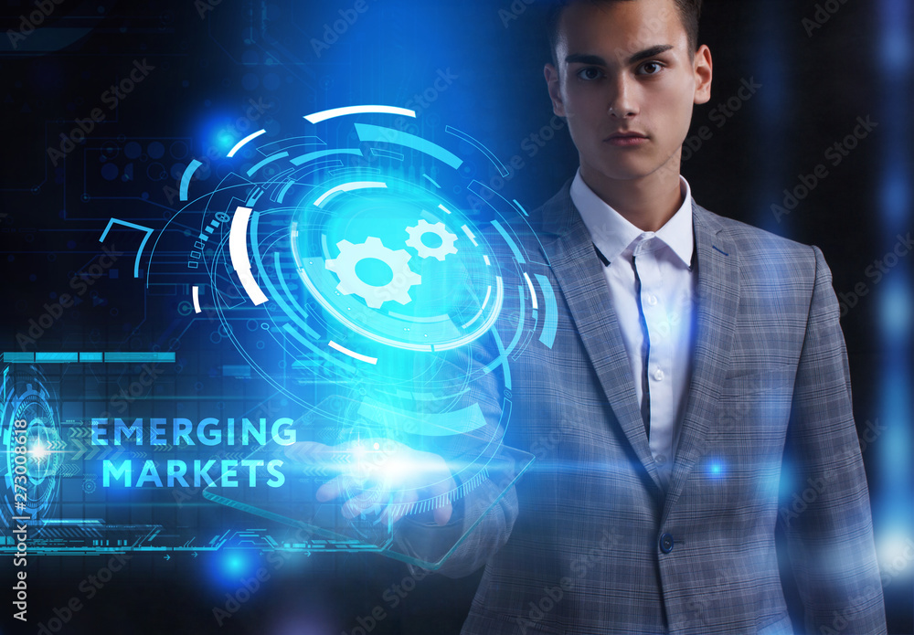 The concept of business, technology, the Internet and the network. A young entrepreneur working on a virtual screen of the future and sees the inscription: Emerging markets The concept of business, technology, the Internet and the network. A young entrepreneur working on a virtual screen of the future and sees the inscription: Emerging markets