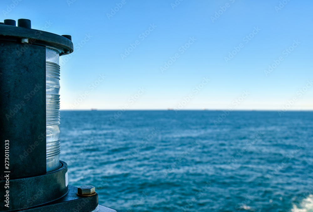 Position light at the stern of a ship during the voyage across the sea. View towards the horizon