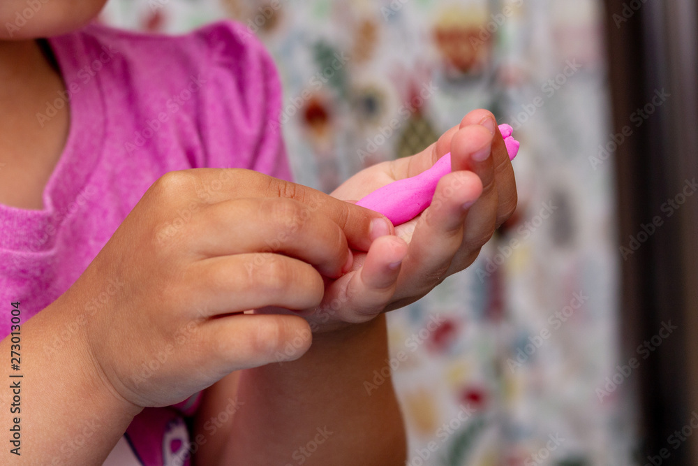 Naklejka premium improving fine motor skills educational games concept, modeling soft clay plasticine children's hands close-up blue background
