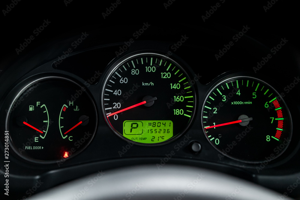 Interior view of car with black salon. Modern luxury prestige car interior: speedometer, dashboard and tachometer  with green backlight and other buttons. Soft focus