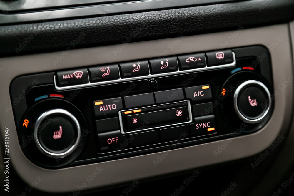 Сlose-up of the car black interior: seat heatting buttons, adjustment of the blower, air conditioner and other buttons. Сlose-up of the car black interior: seat heatting buttons, adjustment of the blower, air conditioner and other buttons.