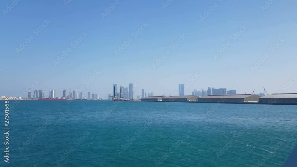 View of the sea port and blue ocean on a sunny day. View of the blue ocean through the porthole of a cruise liner.Sea port and view of the city with skyscrapers on the horizon. View of the sea port and blue ocean on a sunny day. View of the blue ocean through the porthole of a cruise liner.Sea port and view of the city with skyscrapers on the horizon.