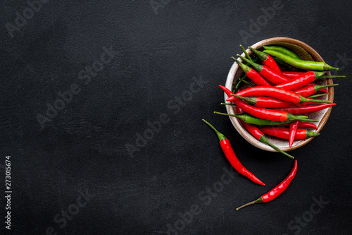 Fresh red and green chilli pepper pattern on black table background top view space for text