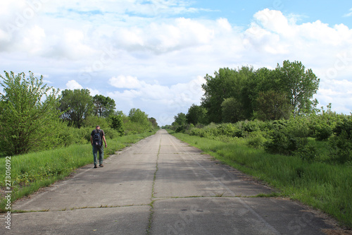 Man walking on an abandoned road at Midewin National Tallgrass Prairie