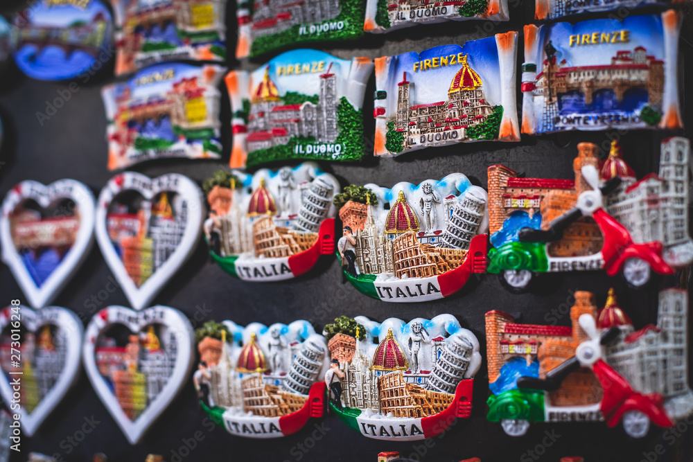 View of traditional tourist souvenirs and gifts from Florence, Tuscany, Italy with toys, masquerade masks, fridge magnets with text View of traditional tourist souvenirs and gifts from Florence, Tuscany, Italy with toys, masquerade masks, fridge magnets with text