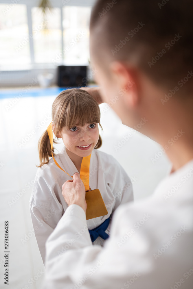 Girl feeling amazing while receiving medal after winning fight