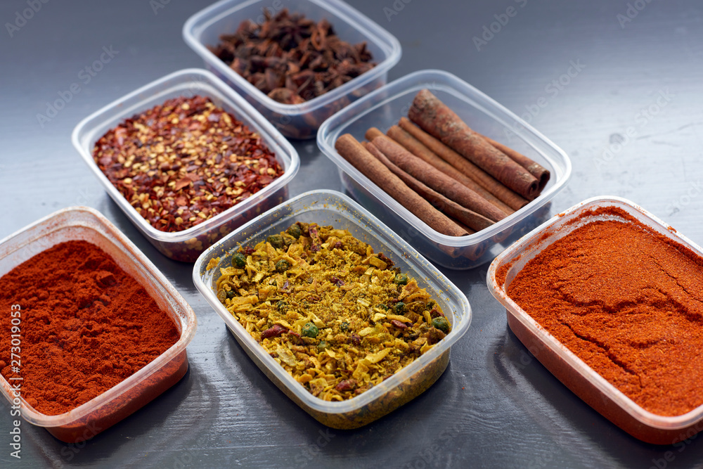 Spices in plastic containers with bamboo brush