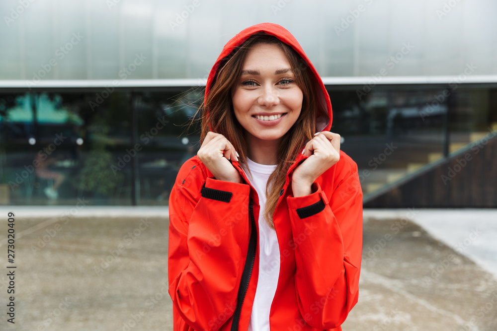 Beautiful excited emotional young happy pretty woman in raincoat posing outdoors. Beautiful excited emotional young happy pretty woman in raincoat posing outdoors.
