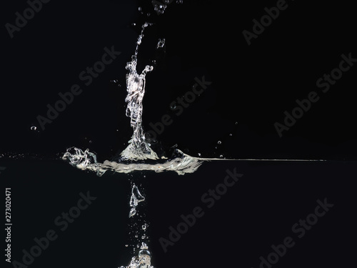Drop of water making splash on surface, isolated on black background, close up view. Water bubbles. Ready to use blending mode to screen or add