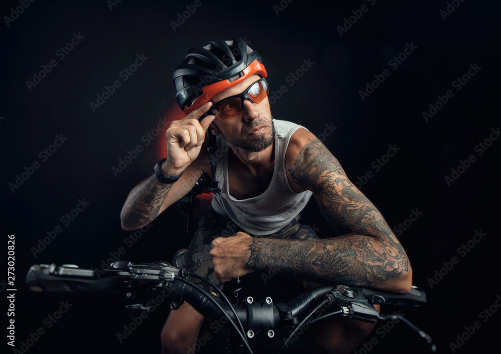 Fototapeta premium guy in a Bicycle helmet emotionally posing on a black background