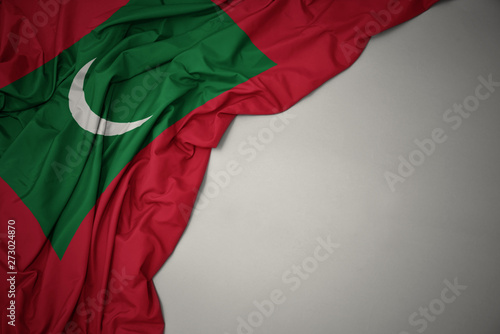 waving national flag of maldives on a gray background.