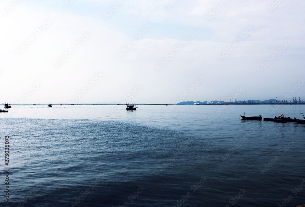 Fishing boat in ocean and building in the city background.