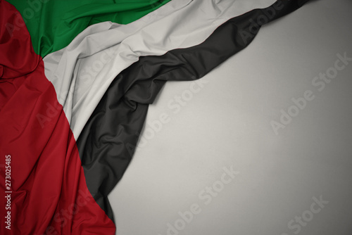 waving national flag of united arab emirates on a gray background. photo