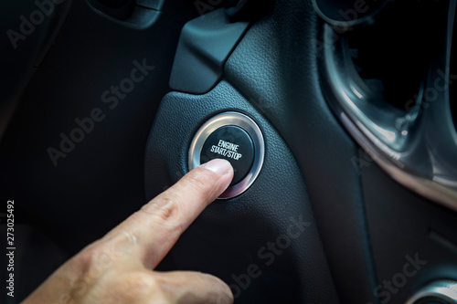 hand pushing a button to start car engine © duan