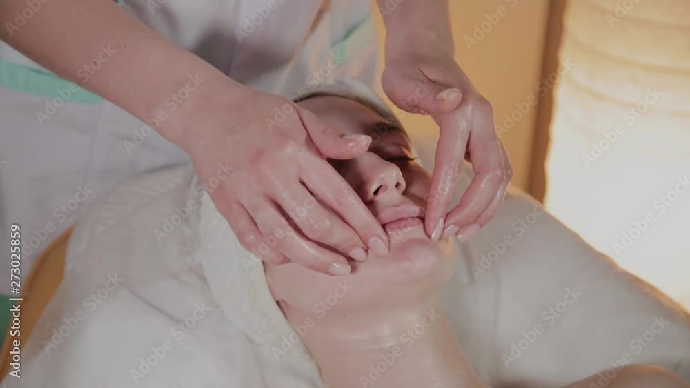 Professional beautician makes a complex massage to a young girl in the cosmetology office. Professional beautician makes a complex massage to a young girl in the cosmetology office.
