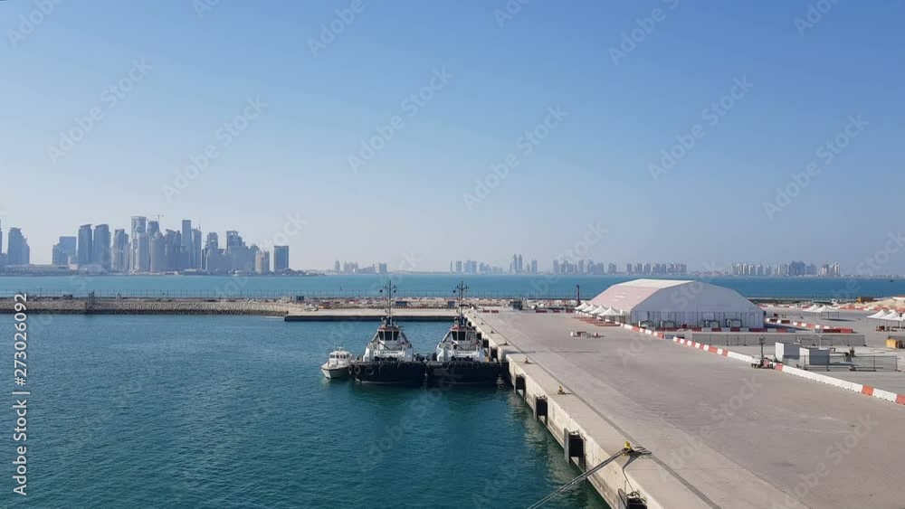 Sea port and view of the city with skyscrapers on the horizon. Sea port with moored ships. Skyscrapers on the background of blue sky. Sea port and view of the city with skyscrapers on the horizon. Sea port with moored ships. Skyscrapers on the background of blue sky.