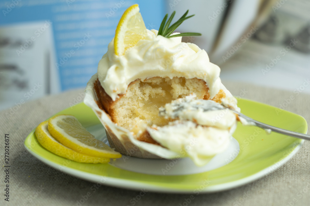 Beautiful dessert, close up eating, food porn, tasty dessert lemon cupcake with curd filling, cheese cream, lemon, rosemary, blue background at linen tablecloth. Beautiful dessert, close up eating, food porn, tasty dessert lemon cupcake with curd filling, cheese cream, lemon, rosemary, blue background at linen tablecloth.