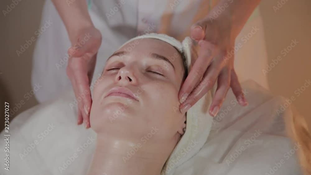 Professional beautician makes a complex massage to a young girl in the cosmetology office. Professional beautician makes a complex massage to a young girl in the cosmetology office.