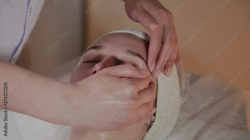 Professional beautician makes a complex massage to a young girl in the cosmetology office. Professional beautician makes a complex massage to a young girl in the cosmetology office.
