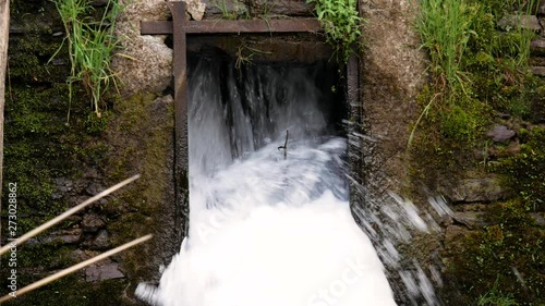 Waterfall throguh a dam made of woods and rocks
