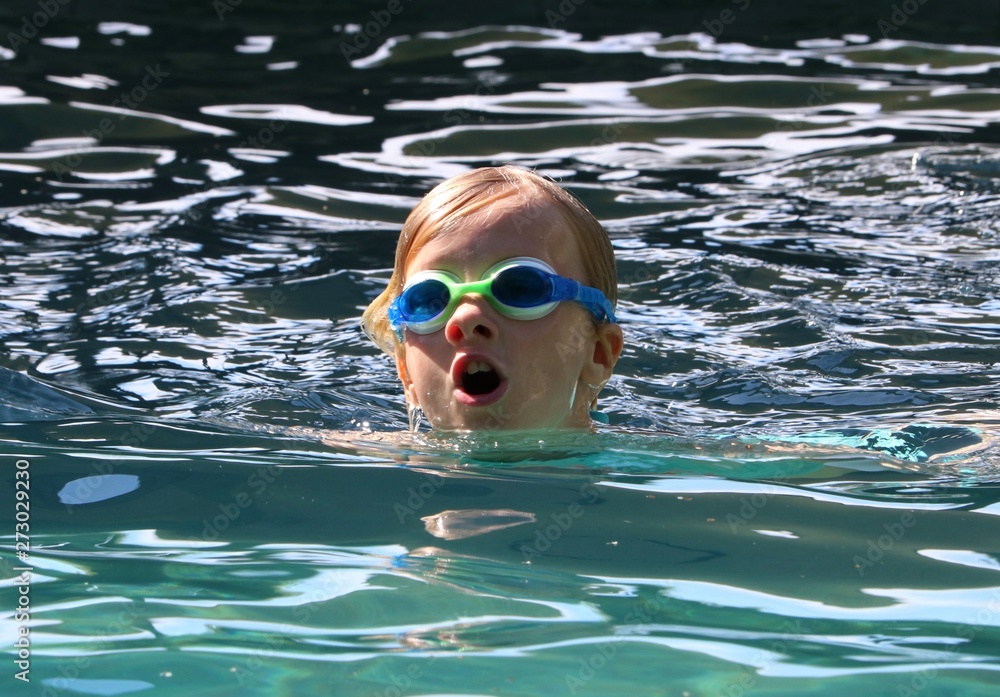 Young girl coming up for air while swimming