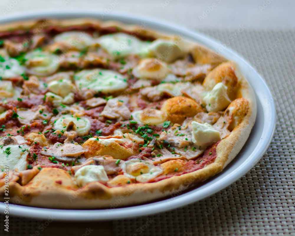 Fresh pizza with cheese, mushrooms and greenery on gray background. Fresh pizza with cheese, mushrooms and greenery on gray background.