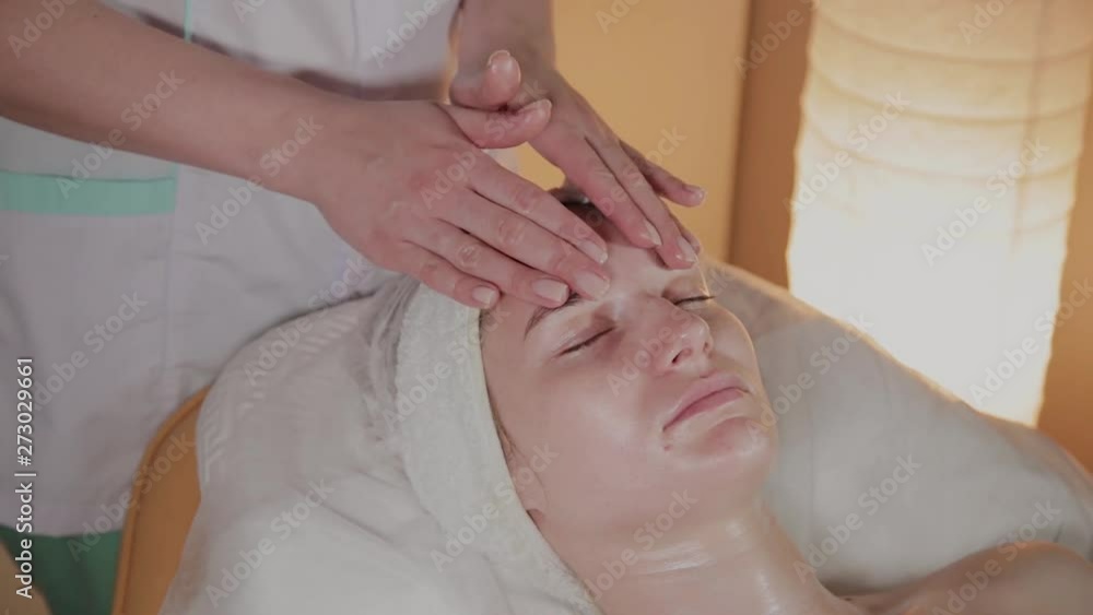 Professional beautician makes a complex massage to a young girl in the cosmetology office. Professional beautician makes a complex massage to a young girl in the cosmetology office.
