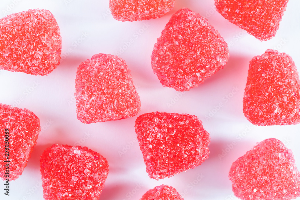 Red jelly sweets close-up on a light background. The concept of bright sweets, harmful delicacy. Flat lay, minimalism, top view. Red jelly sweets close-up on a light background. The concept of bright sweets, harmful delicacy. Flat lay, minimalism, top view.