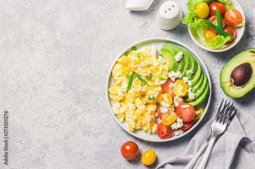 Bild auf Leinwand Scrambled eggs with cherry tomatoes , avocado feta cheese and olive oil