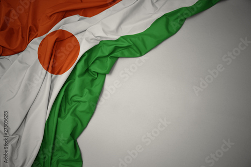 waving national flag of niger on a gray background.