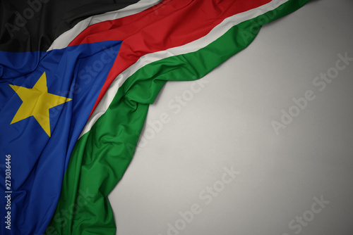 waving national flag of south sudan on a gray background.