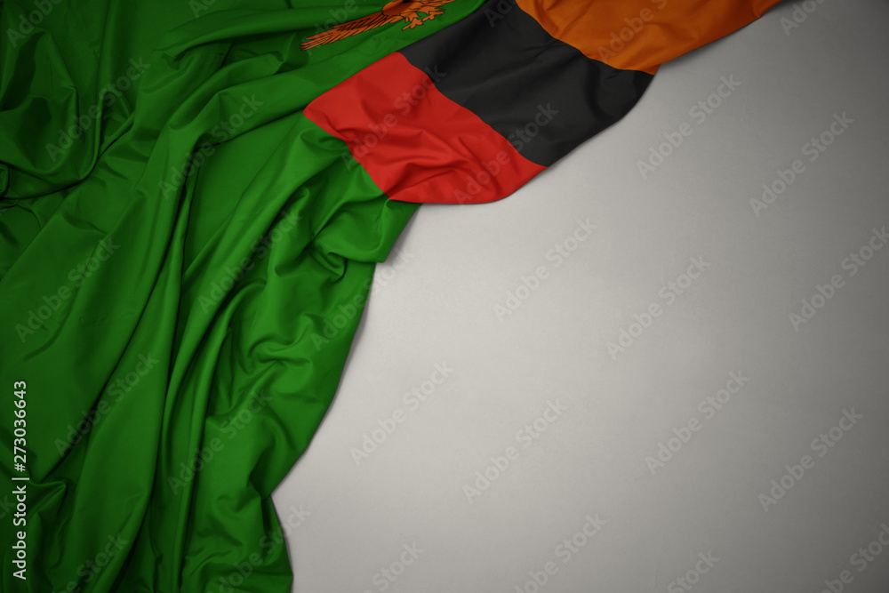 waving national flag of zambia on a gray background.