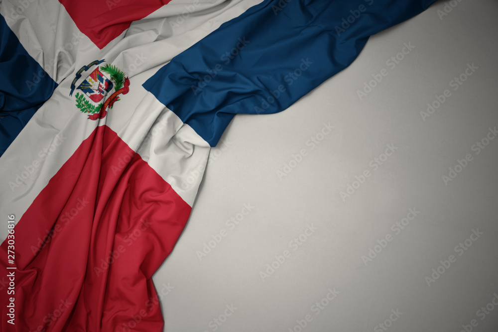waving national flag of dominican republic on a gray background. - obrazy, fototapety, plakaty 