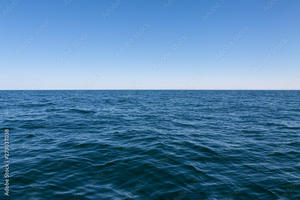 Background, small waves of the sea, and above them the blue sky. Background, small waves of the sea, and above them the blue sky.