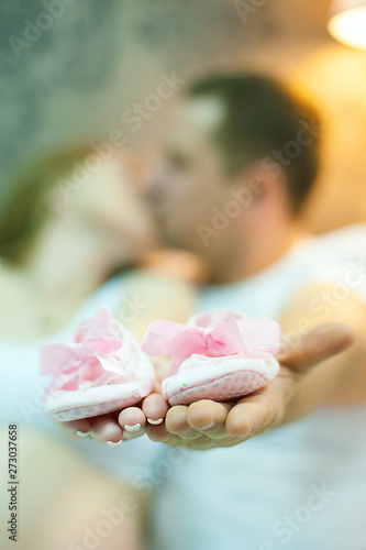 поцелуй, беременность, пара, мама и папа, держут в руках детские тапочки, обувь для новорожденного, розовая детская обувь.jpg