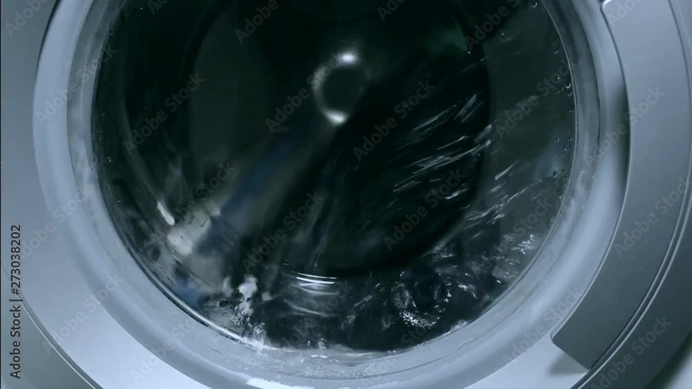 Washing things in the washing machine. The rotation of the drum of the washing machine close-up. Washing things in the washing machine. The rotation of the drum of the washing machine close-up.