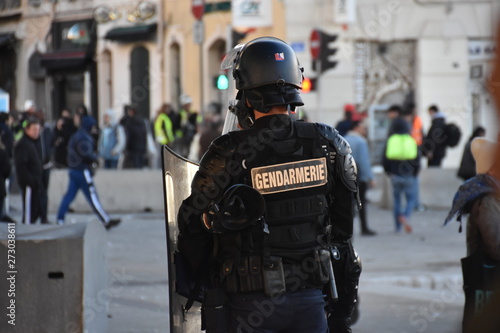 Helmeted gendarme photographed from behind during a protest