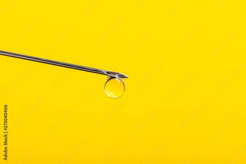Needle with drop isolated on yellow background. Needle with drop isolated on yellow background.