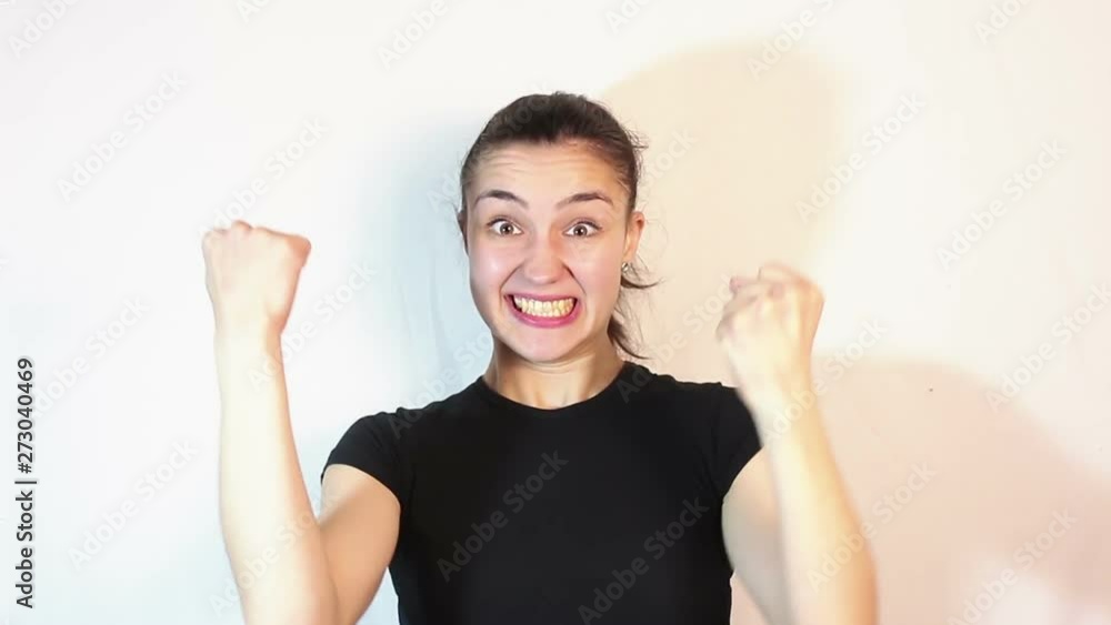 A young beautiful girl in a good mood smiles, says yes and makes a hand gesture. Portrait on white background A young beautiful girl in a good mood smiles, says yes and makes a hand gesture. Portrait on white background