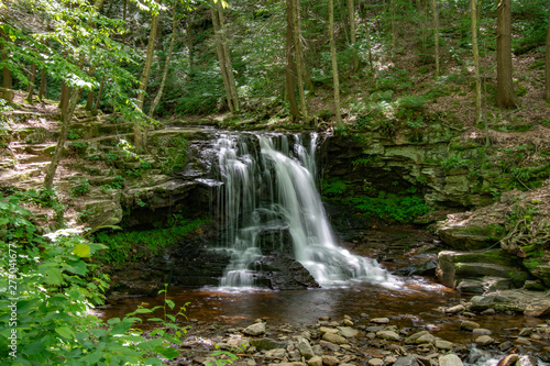 A waterfall in the middle of the forest peacefully flowing 