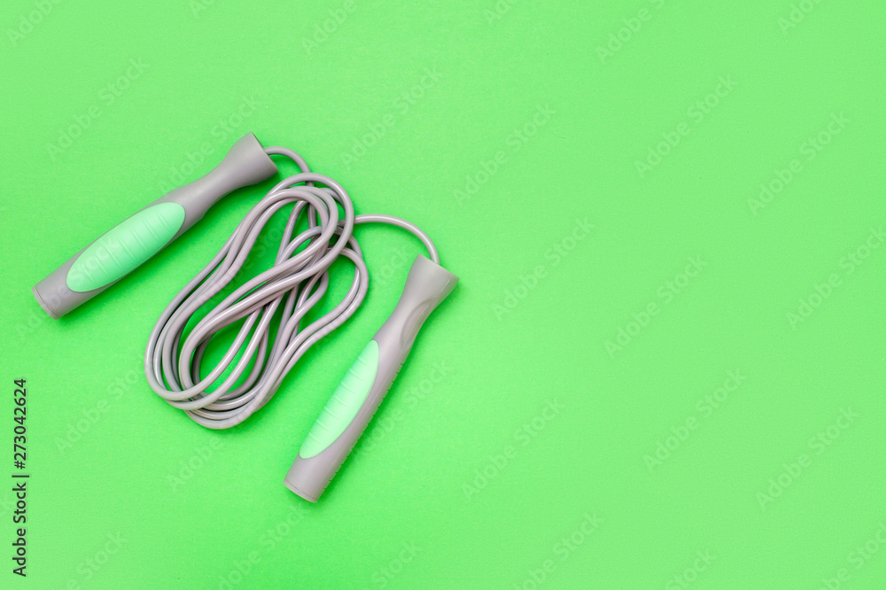 Naklejka premium Jump rope on green background, top view