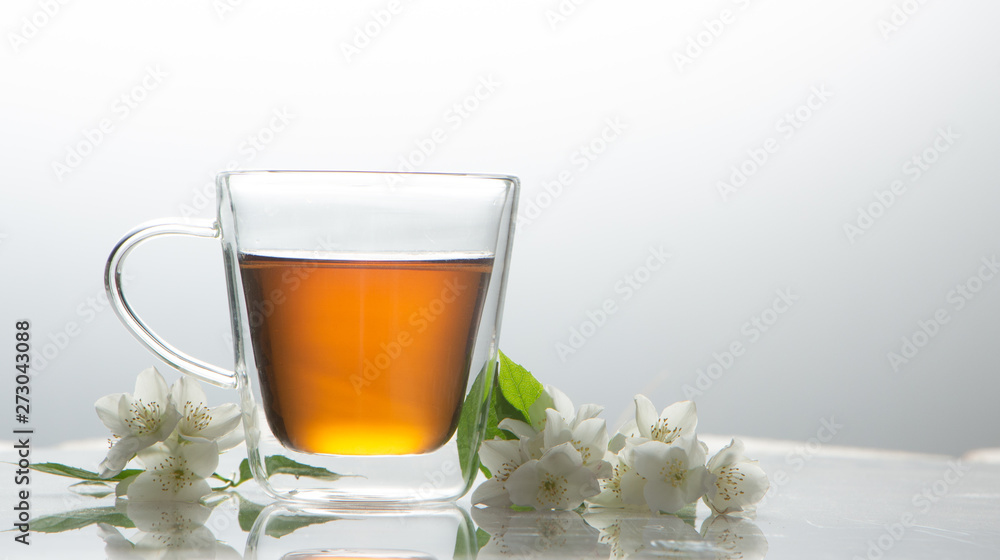green tea with jasmine in a transparent glass thermomug on a white background green tea with jasmine in a transparent glass thermomug on a white background