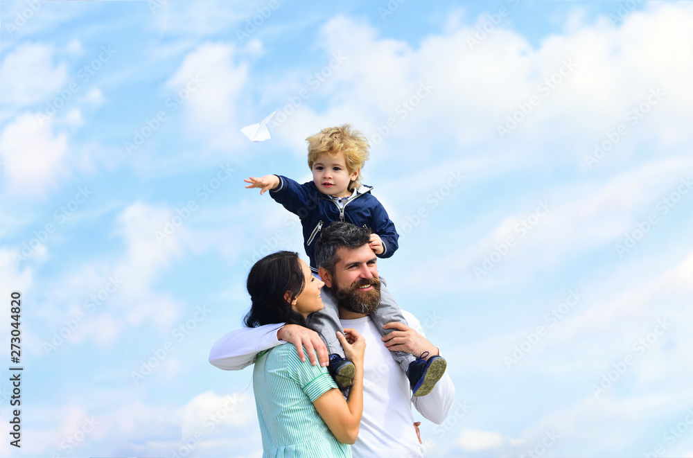 Father mother and son in the park. Freedom to Dream - Joyful Boy Playing With Paper Airplane. Family Time. Parenting. Happy father giving son back ride on sky in summer. Father mother and son in the park. Freedom to Dream - Joyful Boy Playing With Paper Airplane. Family Time. Parenting. Happy father giving son back ride on sky in summer.