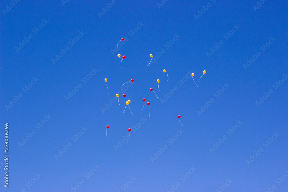 yellow and red balloons fly into the blue sky yellow and red balloons fly into the blue sky