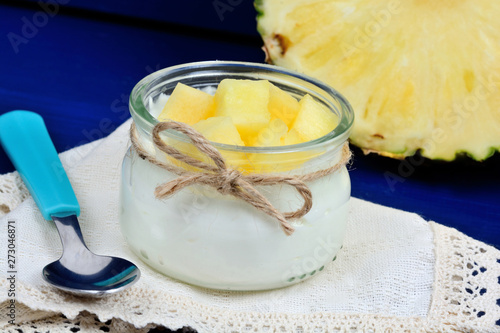 Glass jar with greek yogurt and pineapple cubes