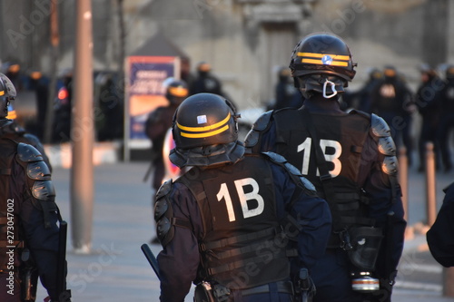 Helmeted police officers photographed from behind during a protest